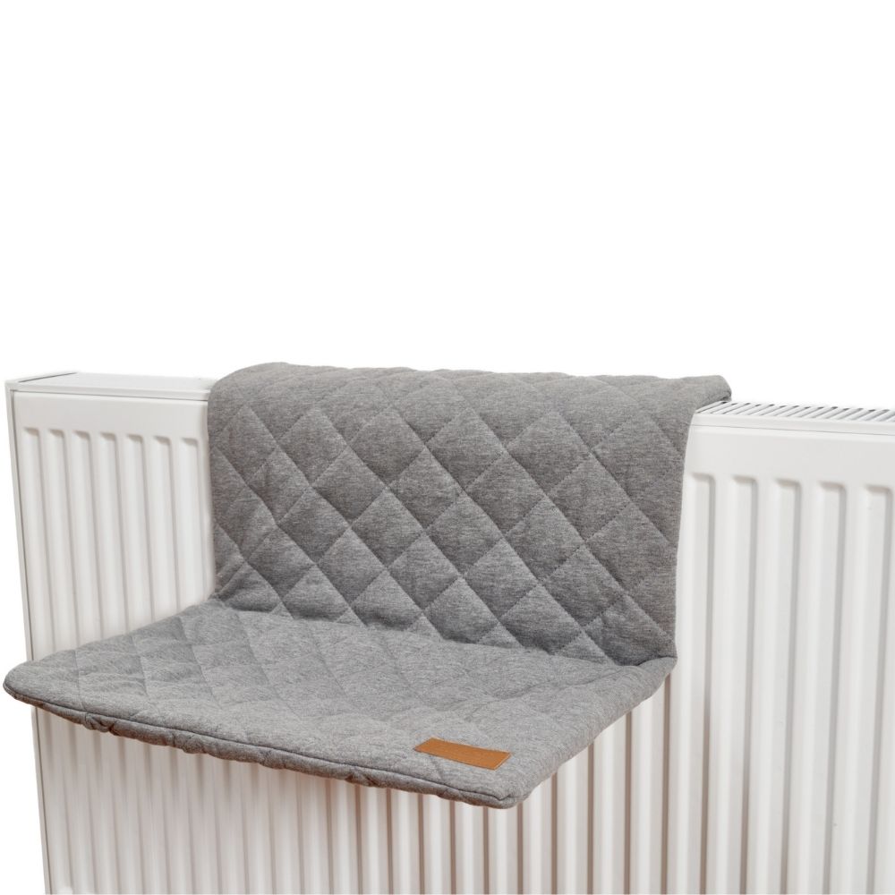 Katzenliege in grau ist an der Oberseite der Heizung befestigt
